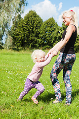 Image showing Mum with a daughter play to a glade