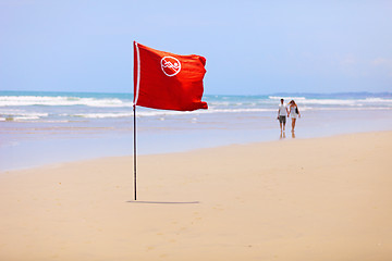 Image showing Tropical beach and a red flag. Do not swim!