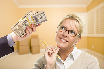 Image showing Woman Being Handed Stacks of Money in Empty Room