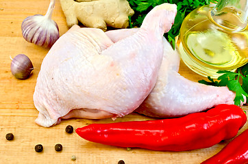 Image showing Chicken legs with vegetables and oil on board