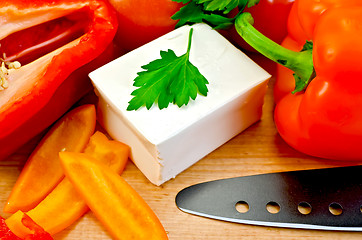 Image showing Feta cheese with a knife and vegetables