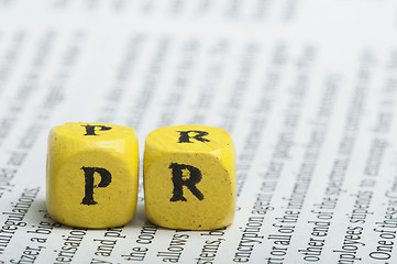 Image showing Word PR.Wooden cubes on magazine