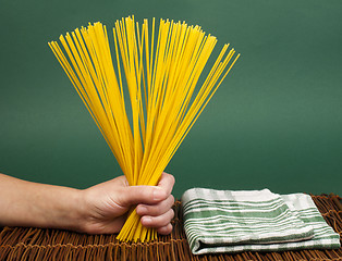 Image showing Female hand holding spaghetti