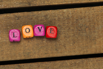 Image showing Word love on multicolored wooden cubes on wood