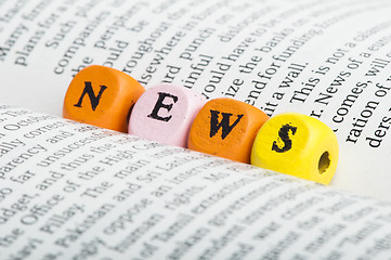 Image showing Word news.Wooden cubes on magazine