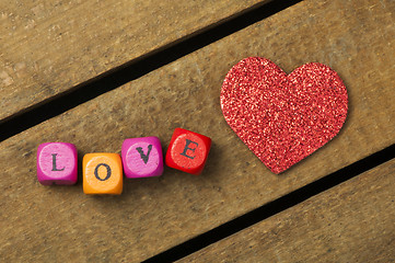 Image showing Word love on multicolored wooden cubes on wooden background