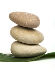 Image showing Stacked stones on base of green leafs