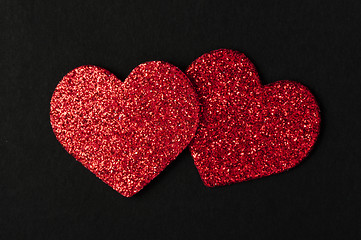 Image showing Red shiny hearts on black background