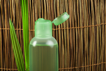 Image showing Green cosmetic bottle and leaf