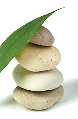 Image showing Stacked stones and green leafs