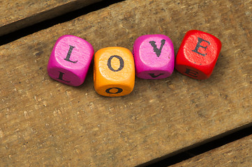 Image showing Word love on multicolored wooden cubes on wood