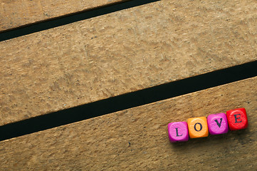 Image showing Word love on multicolored wooden cubes on wood