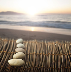 Image showing Sequence of stones on wooden base for spa