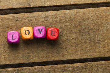 Image showing Word love on multicolored wooden cubes on wood