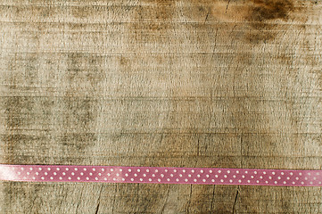 Image showing Pink ribbon for gift wrap on wooden background