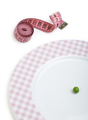 Image showing Plate with one peas. Dumbbell and centimeter measure. 