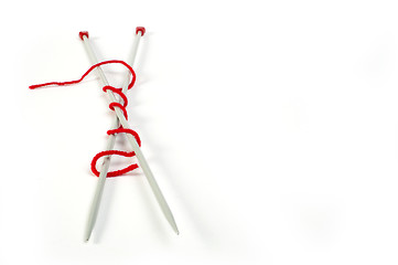 Image showing Knitting skewers and red yarn