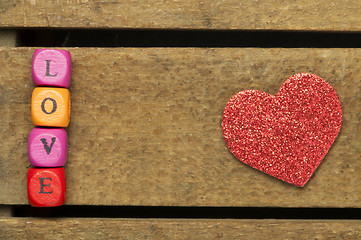 Image showing Word love on multicolored wooden cubes on wooden background