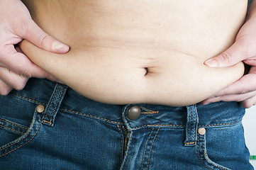 Image showing Woman pinching fat from her abdomen