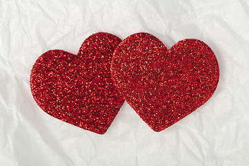 Image showing Shiny red hearts on white paper