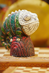 Image showing Figurine of chameleon on a chess-board.