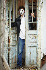 Image showing Guy mime against the old wooden door.