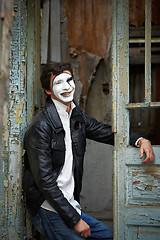 Image showing Guy mime against the old wooden door.