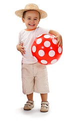 Image showing Cheerful little boy in straw hat, holding red dotted ball