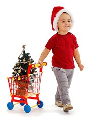 Image showing Little boy pulling shopping cart with Xmas tree