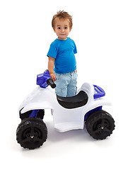 Image showing Little boy standing near toy off road quad