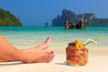 Image showing Coconut cocktail and woman's legs