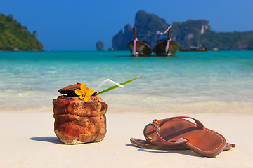 Image showing Coconut cocktail and sandals on the beach