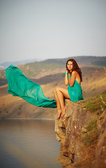 Image showing Girl sitting on the edge of a cliff