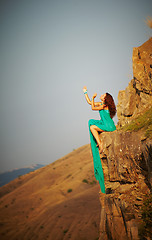 Image showing Girl sitting on the edge of a cliff.