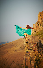 Image showing Girl sitting on the precipice of a cliff.