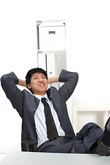 Image showing Laughing Asian businessman with his feet up