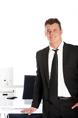 Image showing Handsome businessman standing at his desk