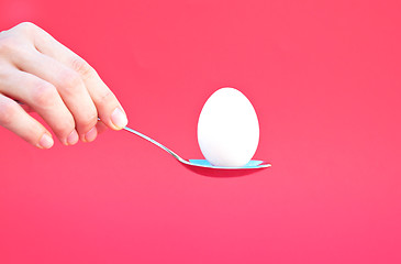 Image showing Hand holding an Egg with a Spoon