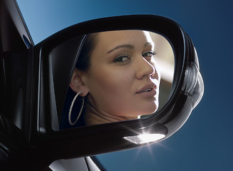 Image showing face in rear-view mirror 