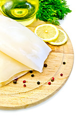 Image showing Squid with lemon and oil on a round board