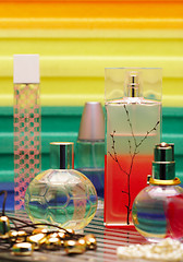 Image showing Glass bottles with perfumery. On a color background with reflect