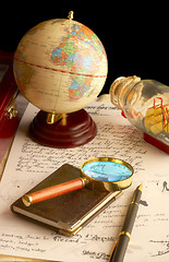 Image showing The globe, magnifier with a notebook and the old manuscript. 