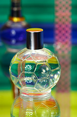 Image showing Glass bottles with perfumery. On a color background with reflect