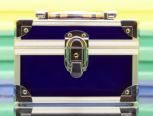 Image showing  Dark blue steel small suitcase with the lock on a multi-coloure