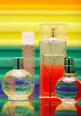 Image showing Glass bottles with perfumery. On a color background with reflection.