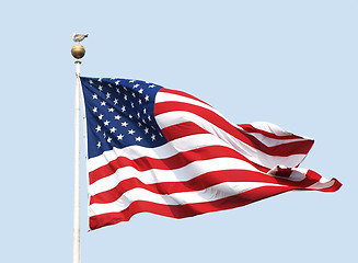 Image showing The American flag flies on a sunny day against a clear blue sky.