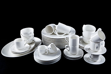 Image showing mixed white dishes cups and plates isolated on black