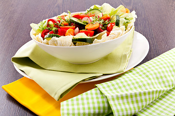 Image showing fresh mixed colorful salad on wooden table 