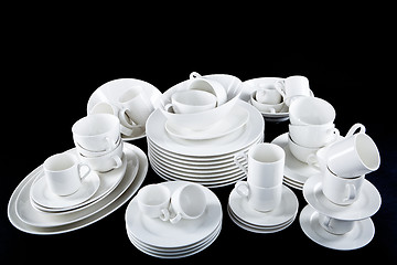 Image showing mixed white dishes cups and plates isolated on black