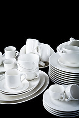 Image showing mixed white dishes cups and plates isolated on black